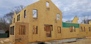 SIP home under construction with ACME Panel structural insulated panels, showing pre-cut window openings